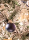 A solid blue Christmas ornament on a flocked Christmas tree