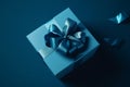 Blue gift box with blue ribbon. Solid blue 3d background