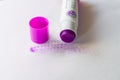 Solid glue in a tube for a child in the form of a purple pencil, which becomes invisible when dried