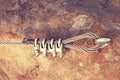 Solid knot on steel rope. Iron twisted rope fixed in block by screws snap hooks. Detail of rope end anchored into sandstone rock