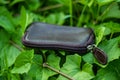 A solid leather black key bag showing on green grass Royalty Free Stock Photo