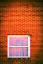 A solid red brick wall with a single glass-paned window in Orwell, Ohio Royalty Free Stock Photo