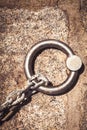 Solid steel ring and mooring lines in a seaport. Rusty iron chain on the ground