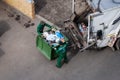 Solid waste collection workers loading garbage truck