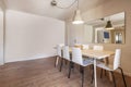 Solid wood dining table next to a mirror in an empty room with chestnut flooring