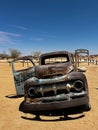 Abandoned old rusty car. Body of a retro car in the sands. Desert in Namibia. Royalty Free Stock Photo