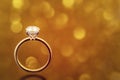 Engagement Diamond Ring on Golden Bokeh Background Royalty Free Stock Photo