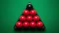 A solitary black snooker ball disrupts the sea of red, positioned within the triangular frame