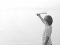 Solitary boy playing with his toy airplane Paper