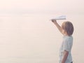 Solitary boy plays with his toy airplane Paper