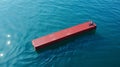 Solitary cargo container lost at sea, drifting in vibrant blue ocean, aerial view