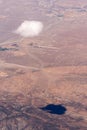 A solitary cloud and its shadow over the desert