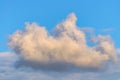 Solitary cloud of torn edges in the evening sky with an orange tint Royalty Free Stock Photo