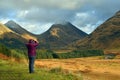 A female tourist taking a cellphone picture in Glen Etive Scottish Highlands