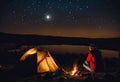Solitary individual seated in front of a tent on a camping site, AI-generated. Royalty Free Stock Photo