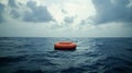 A solitary life raft floating in the middle of the ocean reminding us of the isolation and vulnerability of life at sea