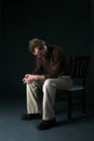 Solitary man sitting on chair with head down Royalty Free Stock Photo