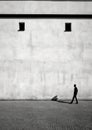 Solitary man walking beside a minimalist building with small windows. Generative AI
