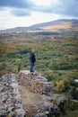 Solitary Moment: Man Standing on Mountain Fortress Ruins, Taking in the Scenery Royalty Free Stock Photo