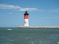 Solitary navigation lighthouse at pier end.