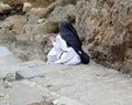 Solitary nun in prayer dressed in a monastic habit and a veil on