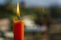 A solitary orange candle casts a warm glow