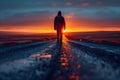 Solitary person walking on empty road towards sunset with reflective wet surface Royalty Free Stock Photo