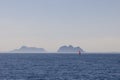 Solitary sailboat with red sail in calm North Sea, Lofoten backdrop Royalty Free Stock Photo