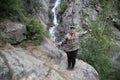 Solitary smiling girl has reached on a cord, waterfall in mountains of Altai