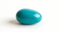 A solitary teal colored egg rests on a clean white surface, isolated and pristine Royalty Free Stock Photo