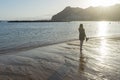 Solitary Teenager walking in the sand of a beach in the sunset having pleasure, relaxing and breathing. Adolescent search or seek Royalty Free Stock Photo