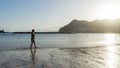 Solitary Teenager walking in the sand of a beach in the sunset having pleasure, relaxing and breathing. Adolescent search or seek Royalty Free Stock Photo