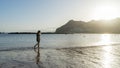 Solitary Teenager walking in the sand of a beach in the sunset having pleasure, relaxing and breathing. Adolescent search or seek Royalty Free Stock Photo