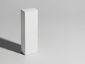 A solitary white rectangular box standing upright on a plain surface, casting a shadow to its right Royalty Free Stock Photo