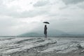 Solitary woman looks at infinity and uncontaminated nature on a stormy day Royalty Free Stock Photo