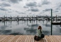 Solitary woman photographer seen taking an image from a newly constructed, wooden Jetty.