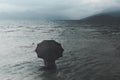 Solitary woman with umbrella waiting for rain sitting in the sea