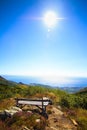 Solitary wooden bench facing the sun shinning in the Mediteranean Sea, in Beigua National Geopark Royalty Free Stock Photo