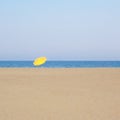 Solitary yellow umbrella on the beach of Cristolu Axedu