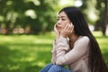 Solitude. Upset Girl Sitting On Lawn In Park And Thinking About Something