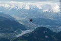 Soll, Tirol/Austria - September 25 2018: A hopper hot-air balloon in the distance above the mountains and above the clouds Royalty Free Stock Photo