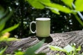 A solo blank white coffee mug in the forest