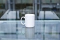 A solo blank white coffee mug on a glass table. Royalty Free Stock Photo