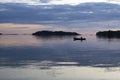 Solo paddling a canoe at dusk in Thirty-Thousand Islands, Ontario