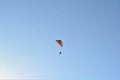 Solo paraglider is flying against the sun on a blue sky on a sunny day in Hungary