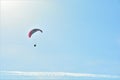 Solo paraglider is flying against the sun on a blue sky on a sunny day in Hungary