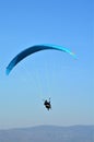 Solo paraglider is flying against the sun on a blue sky on a sunny day in Hungary