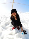 Cute fashionable young woman wearing winter outfit surrounded by snow