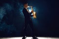 Solo saxophonist in concert outfit performing with intense expression on stage with backlight against dark background