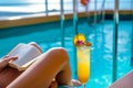 solo traveler reading book by cruise ship pool, cocktail beside Royalty Free Stock Photo